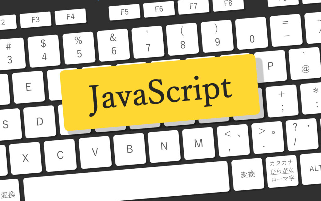 パソコンのキーボードの上にJavaScriptと書いてある紙が載っている写真